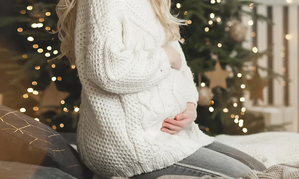 Donna incinta con maglione oversized invernale e jeans
