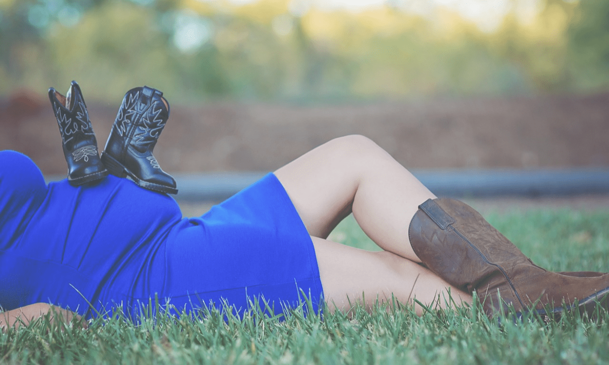 Donna incinta sdraiata con gambe gonfie scoperte